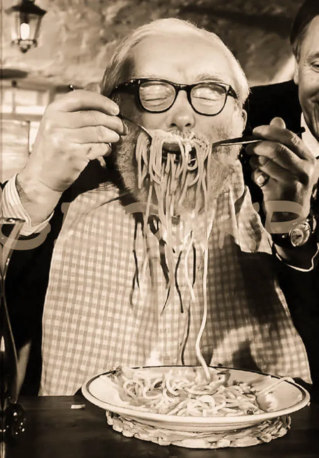 Comensal disfrutando espaguetis en La Búfala de Alaró, imagen en sepia